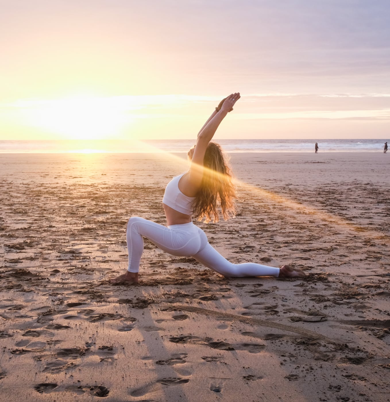 woman doing a yoga pose at sunset