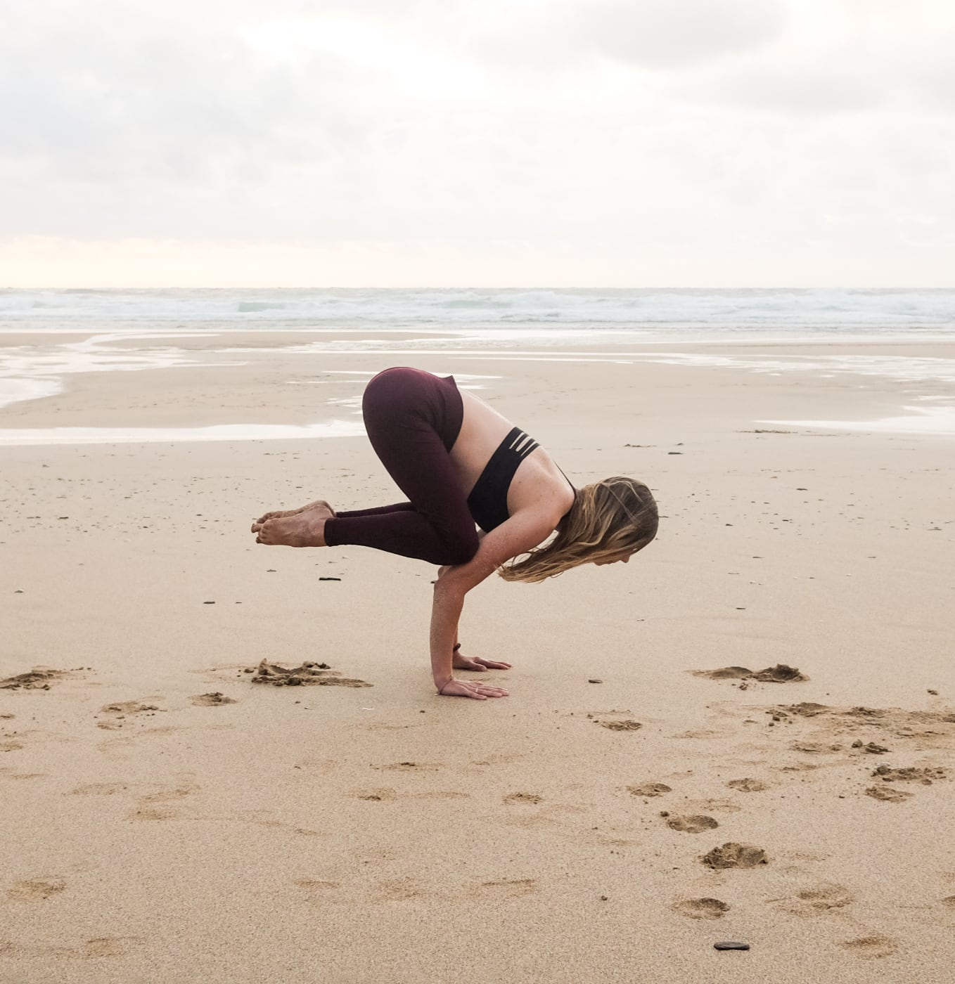 Crow pose on a beach